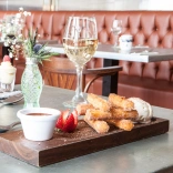 Desserts and wine on a table in a restaurant.